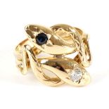 A Sapphire and Diamond Snake Ring, two coiled snakes with a star set round cut sapphire and round