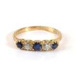 A Sapphire and Diamond Ring, two round cut sapphires spaced by two old cut diamonds, in a carved