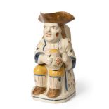 A Pratt Type Pottery Toby Jug, circa 1810, of traditional form, seated holding a jug of ale, wearing