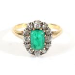 An Emerald and Diamond Cluster Ring, an octagonal cut emerald in a claw setting, within a border