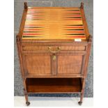 A Victorian Walnut Gaming Trolley, late 19th century, the leather top above a long frieze door