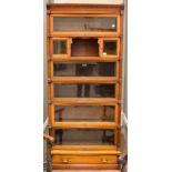 An Oak and Metal Bound Six Piece Sectional Bookcase, circa 1900, five tiers with hinged and glazed