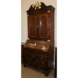 A Walnut Bureau Bookcase, in three sections, the swan neck pediment above two cupboard doors