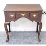 A George III Oak Dressing Table, 18th century in part, with three small drawers above an arched