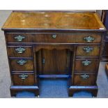 A Figured Walnut and Feather-Banded Kneehole Dressing Table, 20th century, in George II style, the