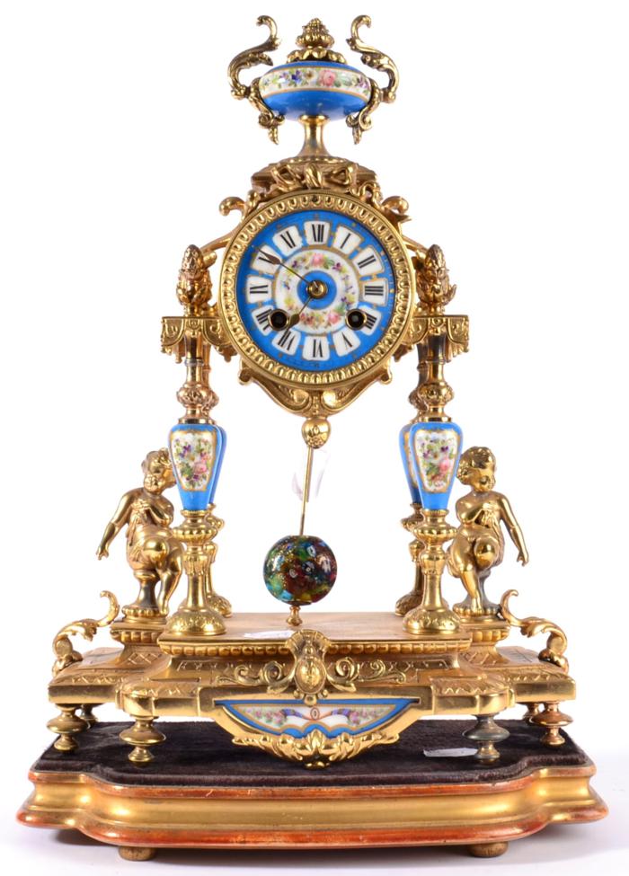 A Gilt Metal and Porcelain Mounted Striking Mantel Clock, circa 1890, surmounted by an urn finial,