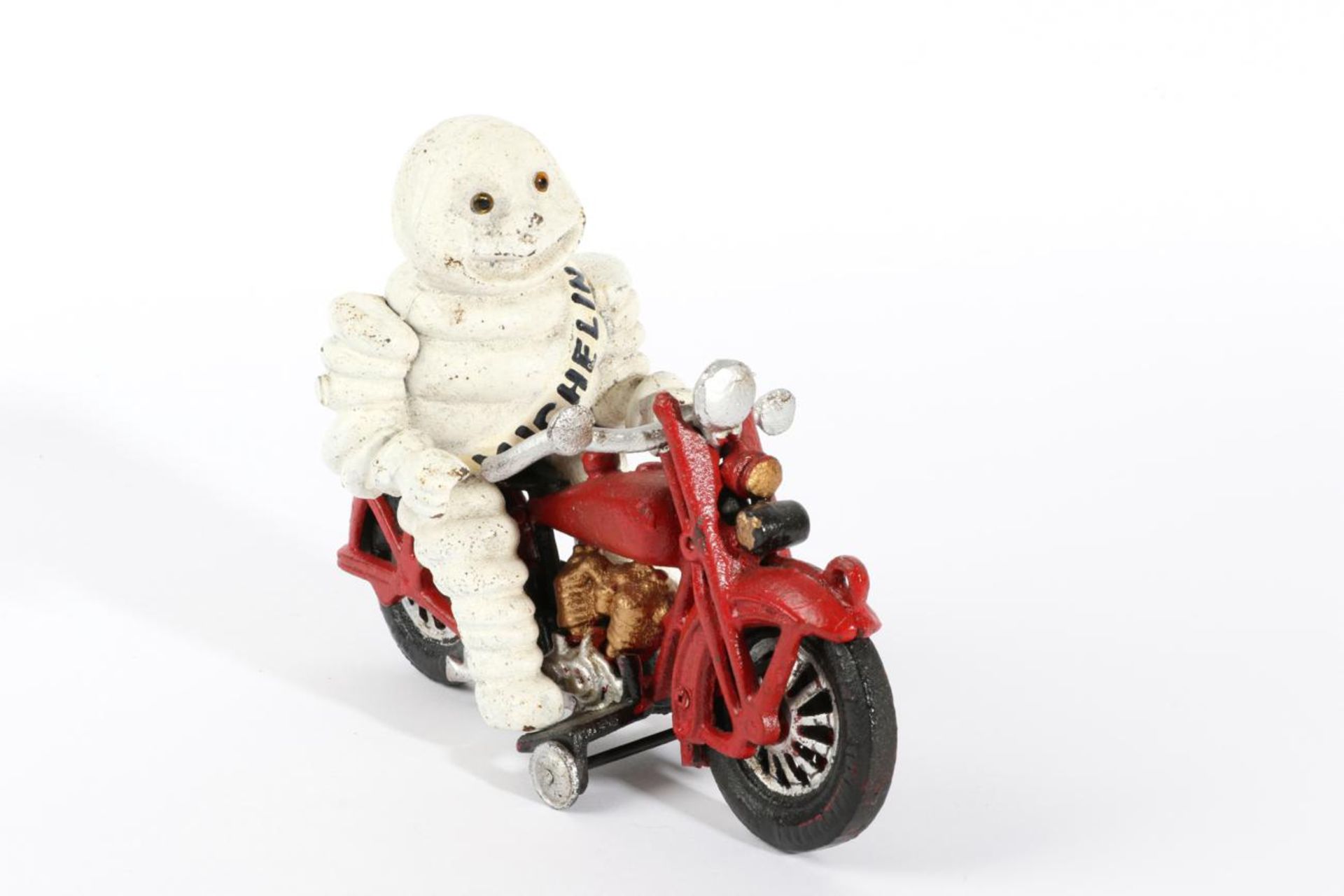 A Michelin Cast Metal Advertising Figure, modelled as the Michelin Man riding a red motorcycle, 16cm