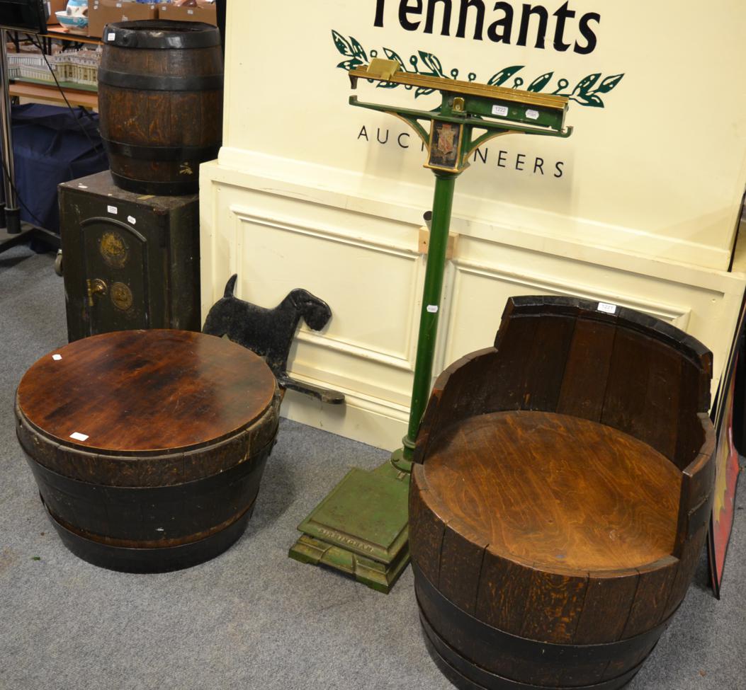 A barrel converted to a seat together with a similar table and with a wrought iron bound barrel, top