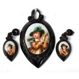 A carved jet pendant and earring suite, the large oval pendant with chased decoration and with a