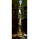 A gilt metal lamp base, late 19th century, of leaf and scroll cast baluster form, on a tricorn base,