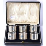 A matched set of six silver napkin rings, Birmingham 1914/18, with engine turned decoration, in a