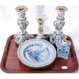 A pair of Delft candlesticks; a Delft caddy painted with an armorial; two Delft plates and a further