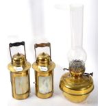 A Victorian brass oil lamp and two later cylindrical form oil lamps with turned wooden handles