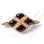 A cabochon garnet and seed pearl brooch, four oval cabochon garnets crossed by a band of seed