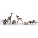 A group of miniature white metal models of animals, comprising: a polar bear; a tiger; a seal; and a