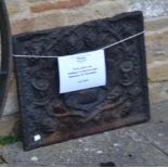 A cast iron back decorated with a coat of arms