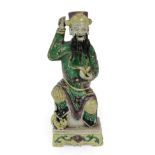 A Chinese Bisque Porcelain Figure of an Immortal, Kangxi, the seated figure wearing a cylindrical