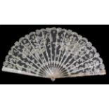 A Large Circa 1890's Honiton Lace Fan, mounted on silvered and gilded pink mother-of-pearl sticks.