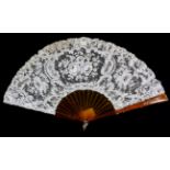 A Circa 1900 Brussels Point De Gaze Lace Fan, mounted on tan resin sticks, resembling blonde