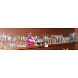 Shelf of glassware - drinking glasses and some paperweights