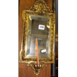 19th c. Italian relief brass wall mirror having mask to top and candle holders below