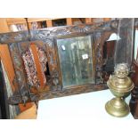 Carved oak hall mirror with coat hooks, and brass oil lamp