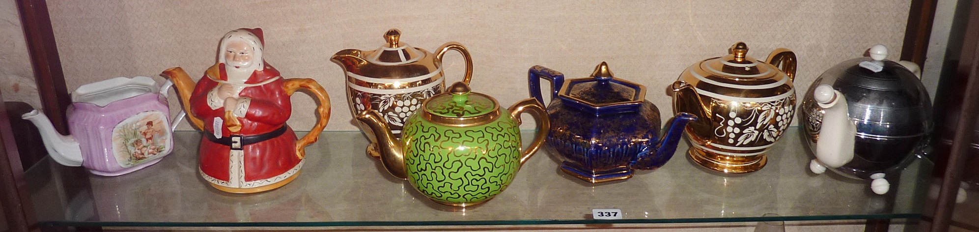 Shelf of teapots inc. an Art Deco Heatmaster, and a Sadler Father Christmas teapot