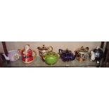 Shelf of teapots inc. an Art Deco Heatmaster, and a Sadler Father Christmas teapot