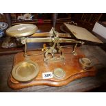 Antique brass letter scales on wooden base with brass weights