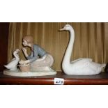 Lladro porcelain figures of a swan and a girl feeding geese and Lladro china shop display sign