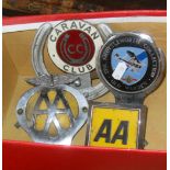Two AA badges, a Caravan Club horseshoe car badge and another