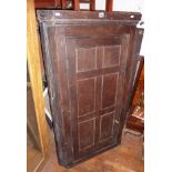 18th c. oak corner cupboard with panelled door enclosing shaped shelves