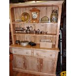 Old pine kitchen dresser having two shelves above two drawers and three cupboard doors