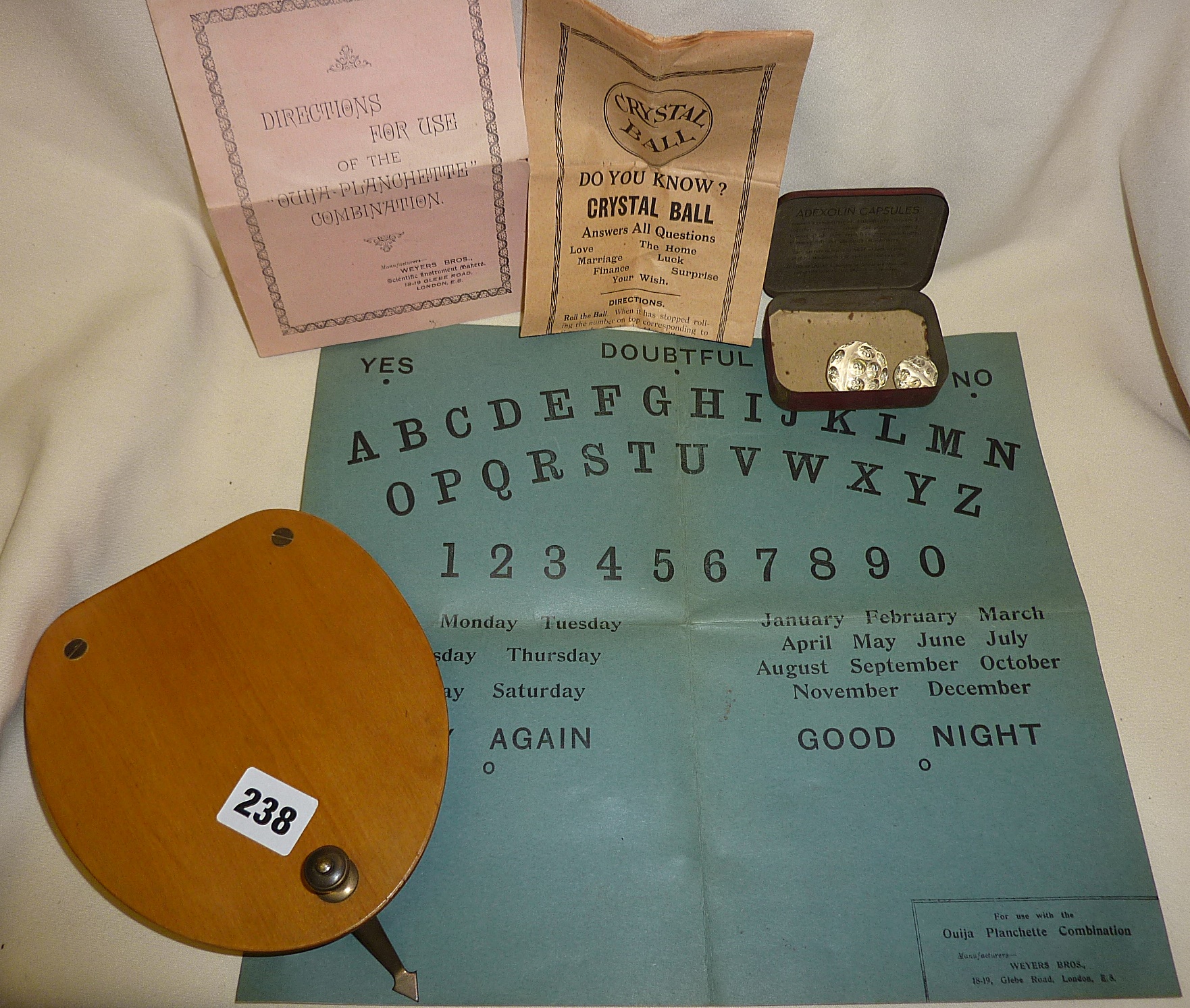 Rare 1920s card Ouija board with wooden planchette and directions leaflet, together with two faceted