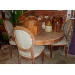 Large circular pine dining table with drawers and a set of four similar upholstered dining chairs