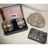 Hallmarked silver pair of napkin rings in case, silver matchbox holder with repousse scene, and
