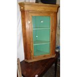 Stripped pine corner cupboard with glazed door