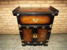 A good quality unusual walnut veneered drinks cabinet on casters with brass detailing and drop down