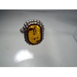 A silver ring stone set with amber.