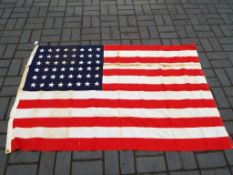 A United States Flag bearing 48 stars in the canton, marked to Dettras Flag Products,