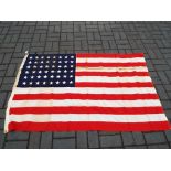 A United States Flag bearing 48 stars in the canton, marked to Dettras Flag Products,