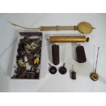 A box containing a quantity of mixed clock accessories including weights, pendulums,