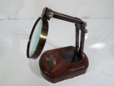 A magnifying glass on a wooden base.