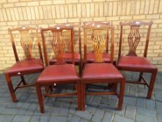 A set of six Edwardian Chippendale style dining chairs with pierced back splats and red drop-in