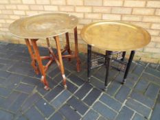 Two middle-eastern circular brass tray topped tables with folding stands [2] - This lot MUST be