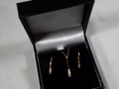 A lady's 9 carat gold 20 point diamond stick pendant and earring set, approx 2.