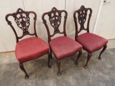 Three Chippendale style dining chairs with pierced and carved back splats,
