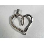 A hallmarked 9 carat white gold and diamond heart pendant.