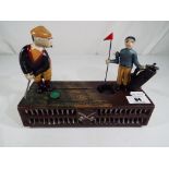 A cast iron mechanical money bank in the form of a golfer and a caddy - This lot MUST be paid for