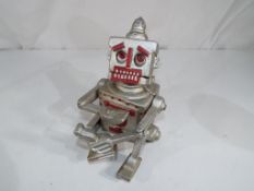 A cast iron novelty money bank in the form of a robot, approximately 17 cm (h).
